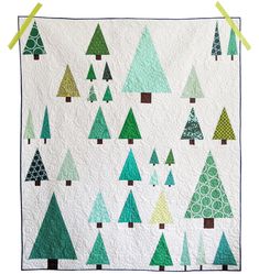 a quilted christmas tree wall hanging on a wall with green tape around the edges