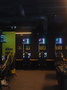 several video game machines are lined up in a room with yellow and black walls,