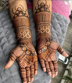 two hands with henna tattoos on them