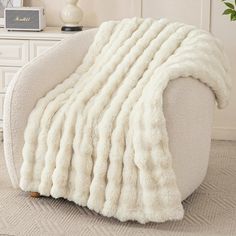 a large white blanket sitting on top of a chair