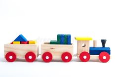 a wooden toy train with colorful blocks on the front and back wheels, against a white background