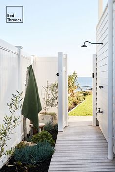 an open door leading to the beach side yard with plants and trees on either side