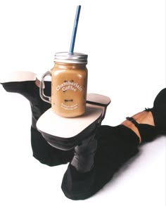 a person wearing black gloves and holding a mason jar