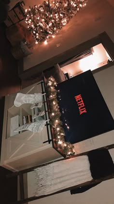 an open book sitting on top of a white table next to a christmas light garland