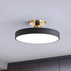 a black and gold circular light fixture in a kitchen