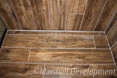 a bathroom with wood flooring and tile on the walls