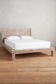 a white bed sitting on top of a wooden floor