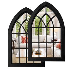 two black arched windows in front of a white couch and coffee table with red pillows on it