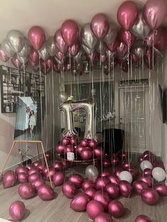 a room filled with lots of balloons floating in the air