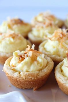 small cupcakes with white frosting and toppings on a plate