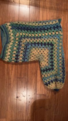 a crocheted blanket laying on top of a wooden floor