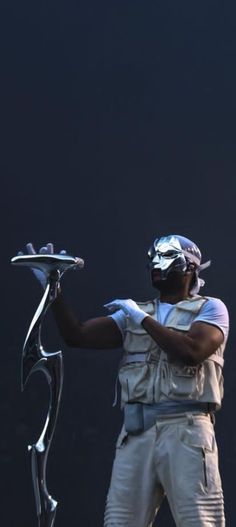 a man in white is holding a tray with silver items on it's sides