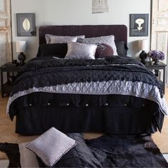 a bed with black and white comforter in a bedroom next to two nightstands