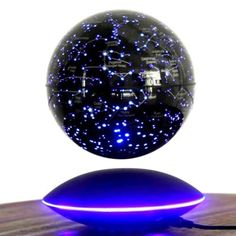 a blue light up ball sitting on top of a wooden table