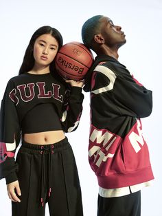 two people standing next to each other holding a basketball