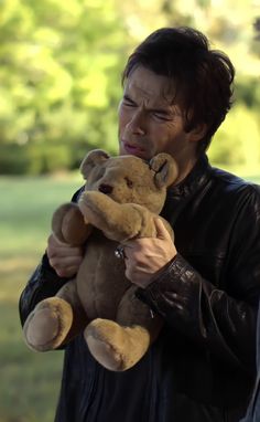 a man holding a teddy bear in his hands