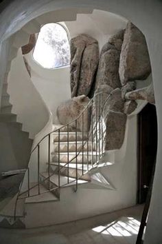 a spiral staircase with rocks on the wall