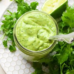 avocado sauce in a jar with cilantro on the side