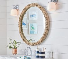 a bathroom sink with a rope mirror above it