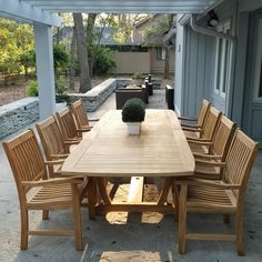 a wooden table with chairs around it on a patio next to an outdoor living area