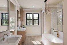 a large bathroom with two sinks and a bathtub next to a window in the corner