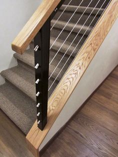 a stair case with metal bars on the bottom and wood handrails at the top