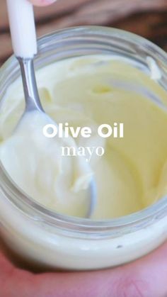 someone is holding a jar of mayonnaise with a spoon in it that says olive oil mayonnaise