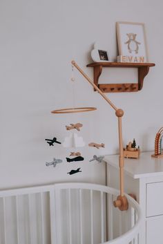 a baby crib with an airplane mobile hanging from it's side