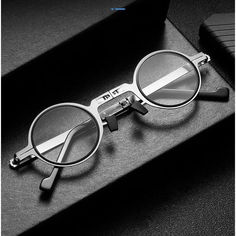 a pair of glasses sitting on top of a black table next to a pen and case