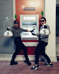 two women dressed in black and white posing for the camera with money bags around their necks