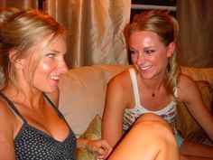 two beautiful young women sitting next to each other on a couch