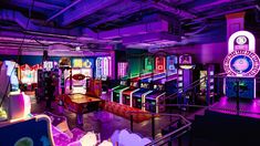 a brightly lit room with arcade machines and neon lights