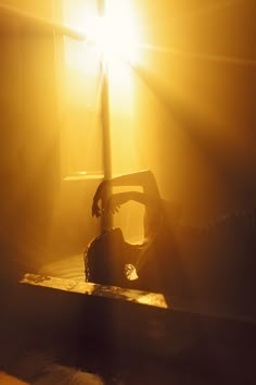 a person laying on the ground in front of a window with sunlight coming through it