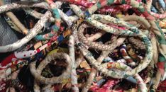 a pile of different types of fabric and beads on top of each other in various colors