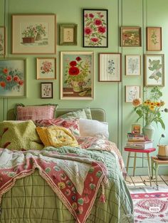 a bedroom with green walls and lots of pictures on the wall above the bedspread