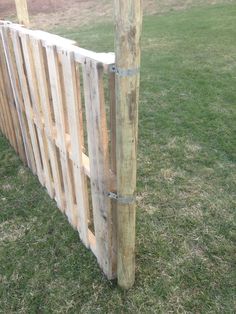 a wooden fence made out of pallets in the grass