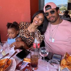 a man, woman and child sitting at a table with food