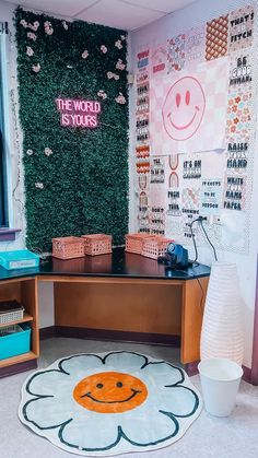 a desk with a flower rug on the floor in front of it and a plant wall behind it