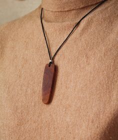 The wooden pendant is handcrafted from reclaimed cherry tree branches. Each piece is handmade and unique, slight variations may occur, contributing to the individuality of each pendant. The wood is treated with a special blend of linseed oil and beeswax, enhancing its natural color and providing protection.   Cherry wood has warm and soothing energy and is believed to promote financial well-being, boost health, and offer protection against otherworldly entities and envious individuals.   This set includes a wooden pendant coated in oil for long-lasting preservation, a waxed cotton cord for comfortable wear, and an elegant gift pouch. Elevate your style with this one-of-a-kind accessory that combines craftsmanship and meaningful symbolism. Pendant size: Approximately 6x1,8 cm (2,36x0,7 inch Wooden Necklace Handmade, Wood Jewelery, Adjustable Knot, Wooden Necklace, Wooden Pendant, Linseed Oil, Wood Pendant, Cherry Tree, Wood Jewellery