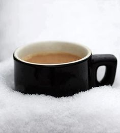 a cup of coffee is sitting in the snow