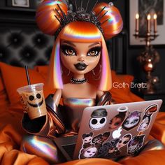 a doll sitting on top of a bed next to a laptop