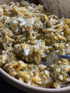 a bowl full of food with bread on the side