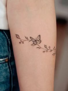 a woman's arm with a butterfly tattoo on the left side of her arm