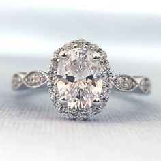 an oval shaped diamond ring with diamonds around it