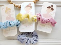 three scrunffle hair ties are hanging on a white door with thank you tags attached to them