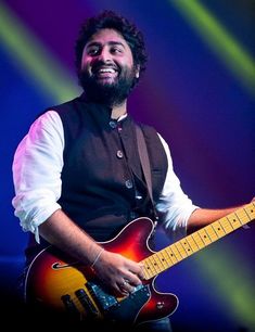 a man with a beard playing an electric guitar