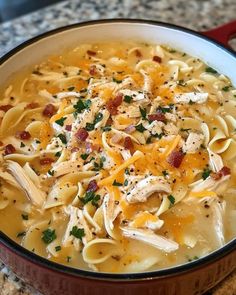 a bowl filled with chicken noodle soup on top of a counter