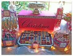 a table topped with lots of different types of candy and candies next to a red box that says christmas