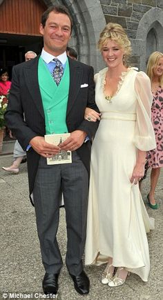 a man in a suit and tie standing next to a woman wearing a white dress