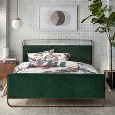 a bedroom with white brick walls, green bedding and plants on the side table